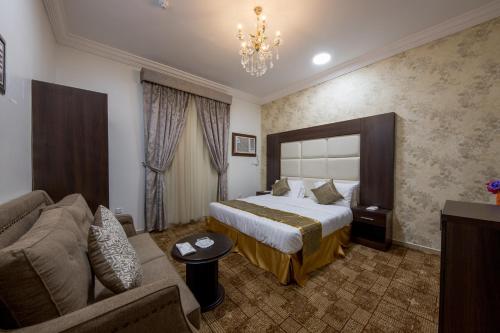 延布Jasmine Beach Hotel Suites的酒店客房,配有床和沙发