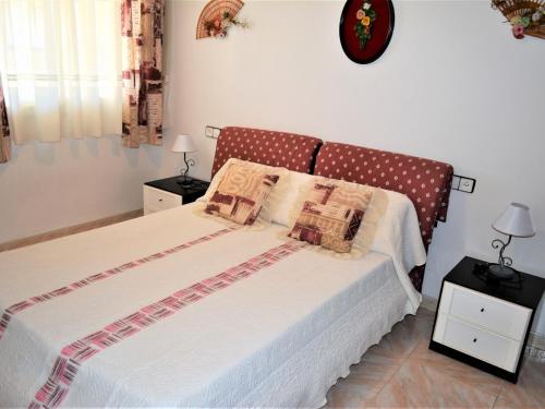 卡拉费尔Villa Service - Barcino的一间卧室配有一张带2个床头柜和2盏灯的床。