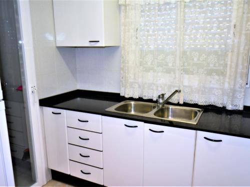 卡拉费尔Villa Service - Barcino的白色的厨房设有水槽和窗户