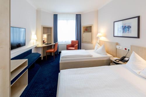马格德堡马格德堡城际酒店的酒店客房设有两张床和电视。