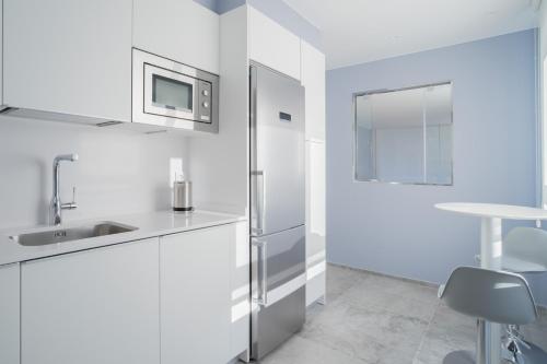 圣塞瓦斯蒂安GOXUE HOME的白色的厨房配有冰箱和水槽