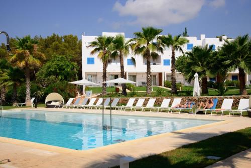 卡拉林亚伊维萨岛卡拉莱亚度假酒店的一座带躺椅的游泳池和一座建筑