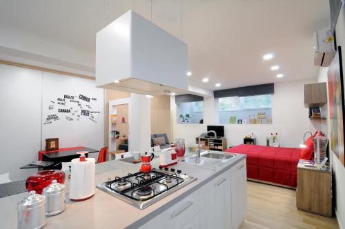 皮亚扎-阿尔梅里纳Folco Studio Apartment的一间厨房和一间带红色沙发的客厅