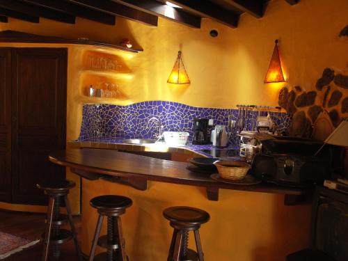 蒂亚斯Casa Niro的一间酒吧,厨房内摆放着蓝色瓷砖,配有凳子