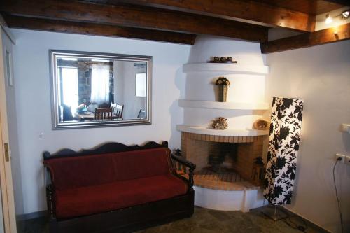 基斯诺斯Dryopida House的客厅设有壁炉和红色沙发。