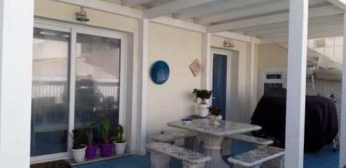 马尔扎梅米CASA CAMPISI Marzamemi的带2张桌子的房间和植物阳台