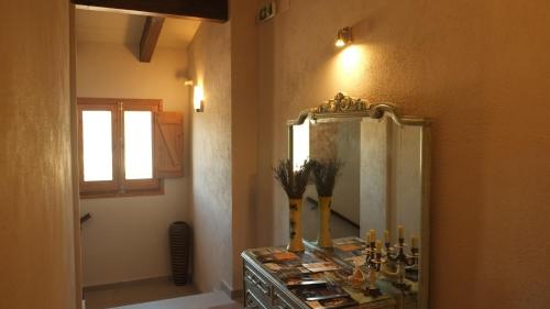 佩雷拉达La Masia de Montpedrós的浴室设有镜子和带蜡烛的梳妆台
