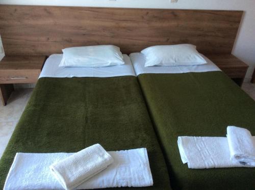 卡尔扎迈纳法尼亚公寓的卧室内的两张床,配有绿色床单和枕头