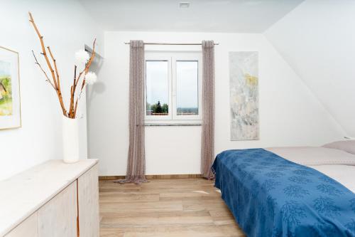 克勒希Ferienhaus im Weingarten的一间卧室设有一张床和两个窗户。