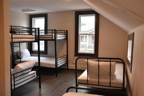 坎莫尔PARTY HOSTEL - The Canmore Hotel Hostel的带两张双层床的客房,设有两扇窗户