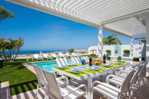 阿德耶VILLA VALENTINA OCEAN VIEW HEATED Pool的海景露台上的白色桌椅