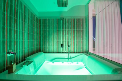 那不勒斯MAIN - Municipio的浴室铺有绿色瓷砖,配有浴缸。