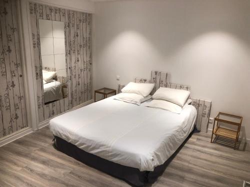 博尼法乔Appartement port bonifacio的卧室配有一张白色大床和镜子