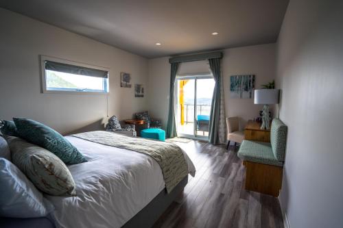 韦克菲尔德Le Bellevue Modern Lodge的卧室配有床、椅子和窗户。