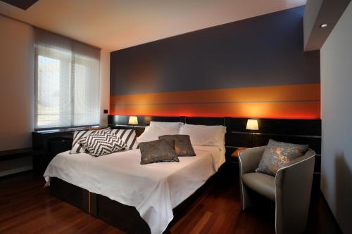 帕尔马诺瓦都市潮流旅馆的一间卧室配有一张床和一把椅子