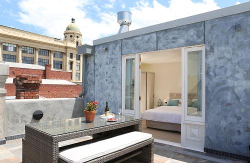 墨尔本Studio 8 - Penthouse的带阳台的客房配有一张床和一张桌子