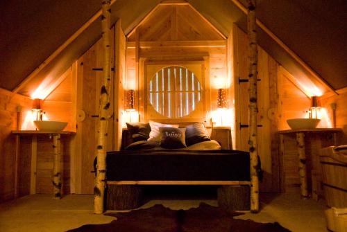 米罗勒莱克尚邦小屋酒店的一间设有床铺的卧室,位于一间灯光的房间