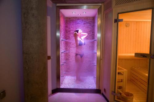 莱昂莱昂中央SpaQH酒店的站在淋浴间的女人