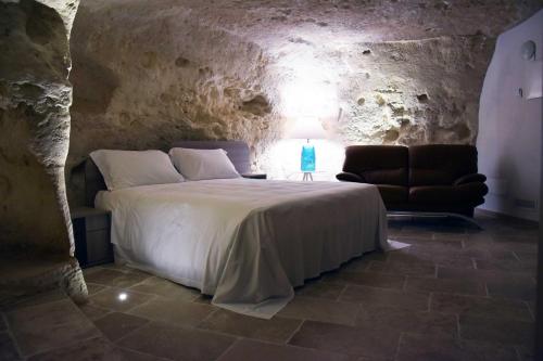 马泰拉5 Elementi Sassi Matera的洞穴内一间卧室,配有一张床和一把椅子