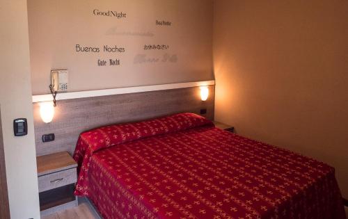 阿米诺艾尔伯格蒙特罗莎餐厅酒店的一间卧室配有一张红色棉被的床