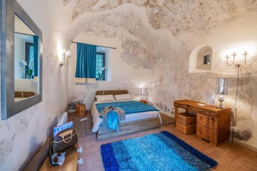 菲纳莱利古雷Locanda La Fortezza的一间卧室配有一张床和蓝色地毯