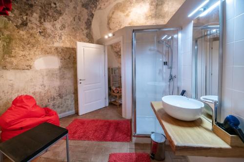 菲纳莱利古雷Locanda La Fortezza的一间带水槽和玻璃淋浴的浴室
