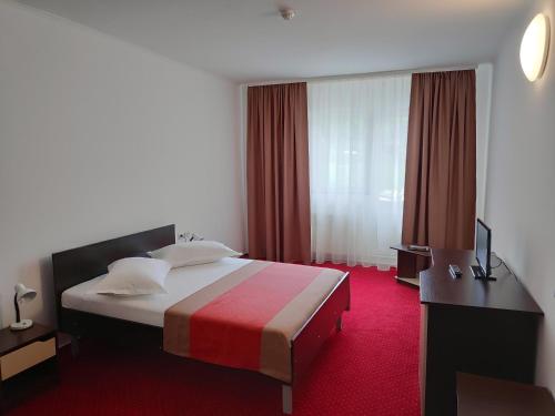 卡库拉塔Hostel Caliman的酒店客房,配有一张铺有红地毯的床