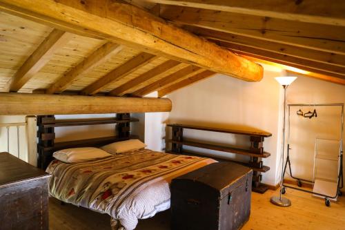 ZognoCasa Vacanza Pratolungo的一间带一张床的卧室,位于带木制天花板的房间内