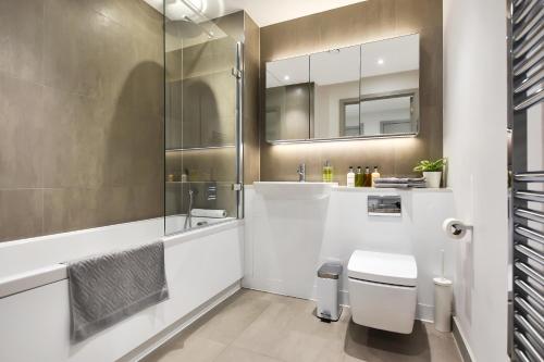 伦敦Esquire Apartments Ealing的一间带卫生间、水槽和镜子的浴室