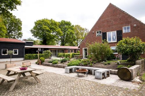 Westerhaar-VriezenveensewijkDe Johanneshoeve的一个带野餐桌的庭院和一座建筑