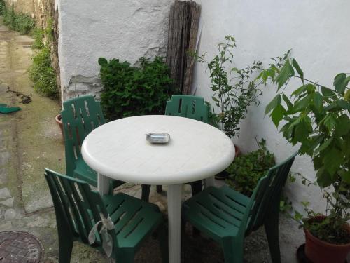 JubriqueJúbrique的院子里的一张白色桌子和四把绿色椅子