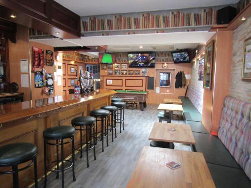 福哈伯斯The Red Lion Tavern的餐厅内带木凳和桌子的酒吧