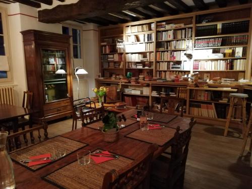 TanlayLa Virgule de Tanlay的一间设有桌子和一些书籍的用餐室