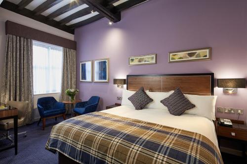 格拉茨克洛斯公牛酒店的酒店客房带一张床、一张桌子和椅子