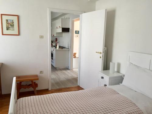 卡尔多纳佐Appartamento Balù的一间白色卧室,配有床和厨房