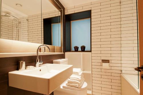伦敦Wigmore Suites Serviced Apartments by Globe Apartments的白色的浴室设有水槽和镜子