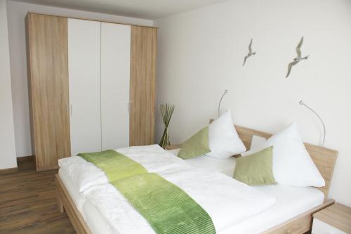 格洛韦Ferienwohnung Störtebekersuite的一间卧室配有带绿色和白色枕头的床
