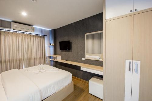 奥南海滩Aonang Ocean View Studio ( The Sea Condo )的卧室配有白色的床和电视