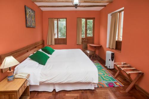 奥兰太坦波SAUCE Hotel Boutique的一间卧室配有一张带橙色墙壁的大床