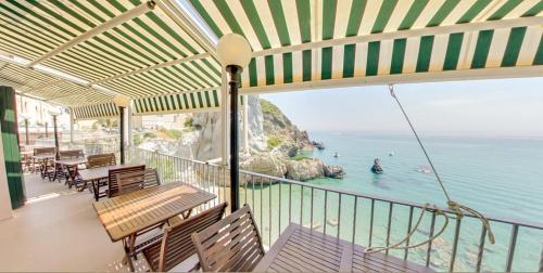 蓬扎Hotel Bellavista的阳台配有桌椅,享有海景。
