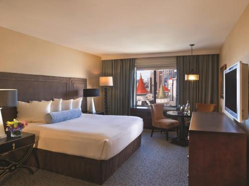 拉斯维加斯神剑大酒店的酒店客房设有一张大床和一张书桌。