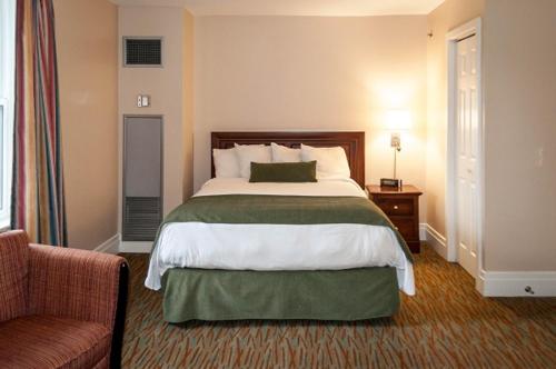 科纳布鲁克格林米尔酒店的酒店客房带一张大床和一把椅子