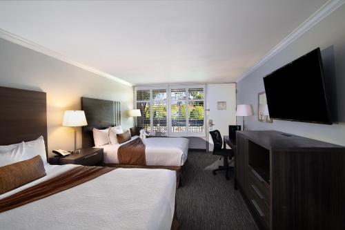 千橡市棕榈树花园酒店的酒店客房设有两张床和一台平面电视。