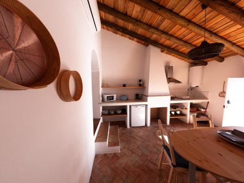 莫托拉Casas de Mértola的厨房以及带木桌的用餐室。