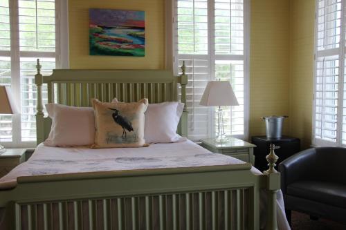 泰比岛Beachview Inn and Spa的一间卧室,配有一张床上的床铺,枕头上有鸟