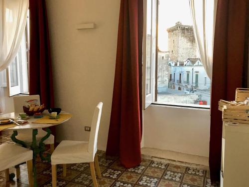 鲁蒂利亚诺Dimora Essenza的一间带桌子和窗户的用餐室
