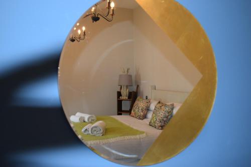 拉夫堡The Manor House at Quorn的卧室的镜子,配有一张床和毛巾
