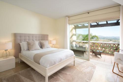 卡拉德米哈斯Luxury townhouse La Cala Golf Resort (Golf, Beach, Nature and Amazing views)的一间带大床的卧室和一个阳台