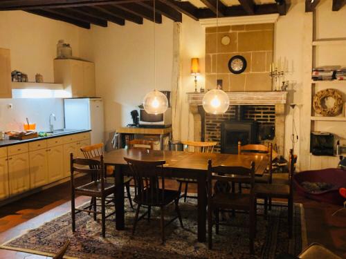 PouilléAu Coeur des Vignes的厨房以及带桌椅的用餐室。