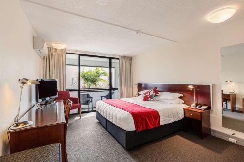 奥克兰The Parnell Hotel & Conference Centre的酒店客房配有一张床和一张书桌及一台电视